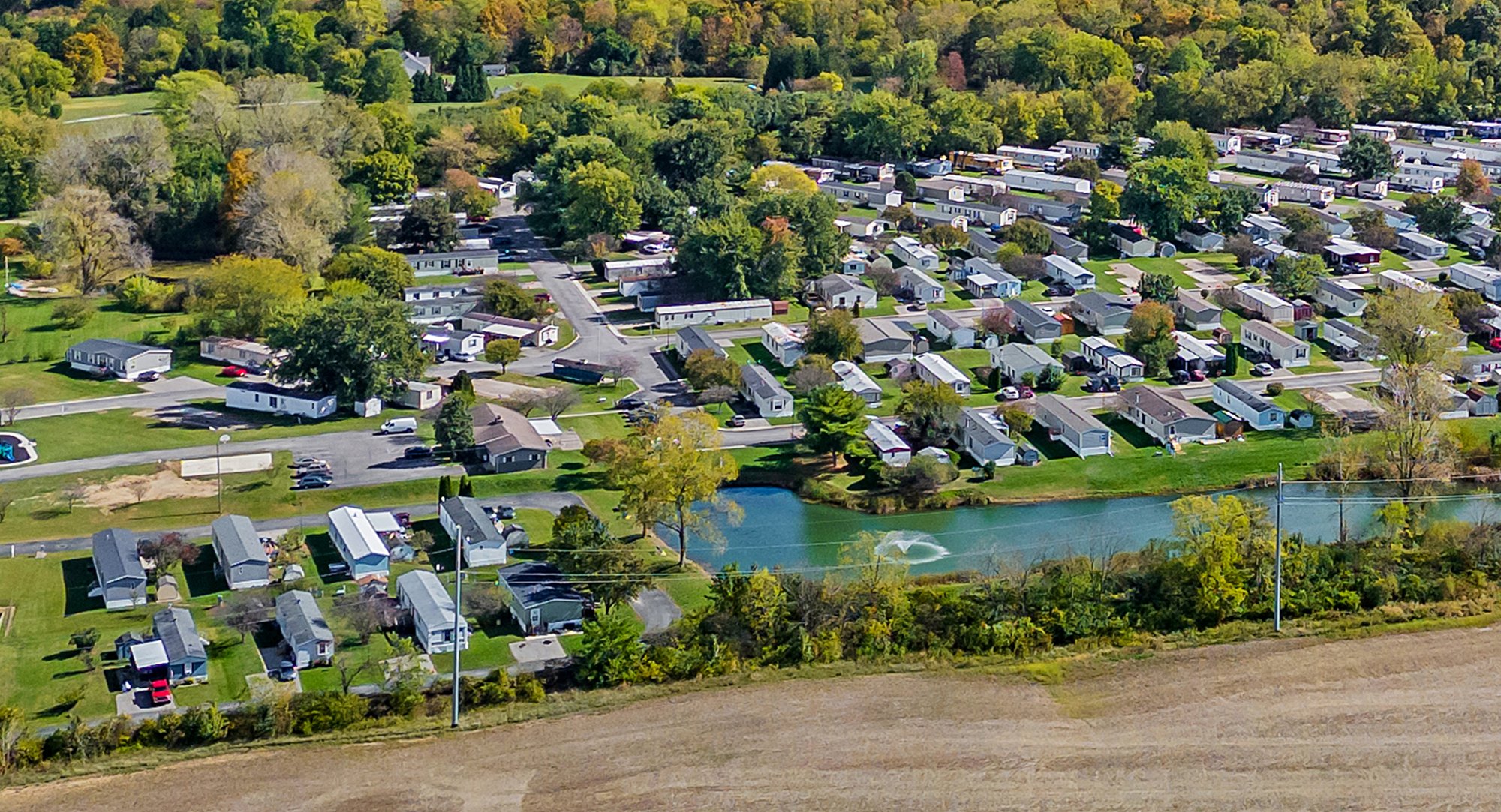 Aerial view of a manufactured home community beside a pond